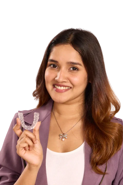 Smiling Precisalign patient holding a clear aligner